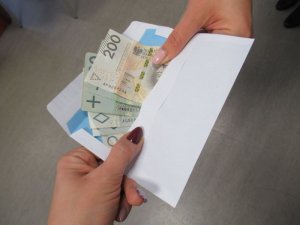 pieniądze w kopercie przekazywane z ręki do ręki